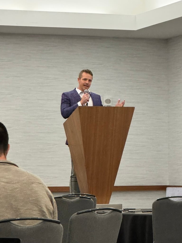 Dr. Stephenson speaking at the podium during the 2025 LegacyRx conference